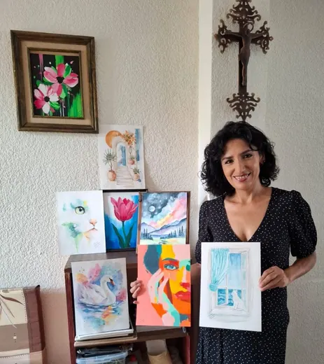 Alumna mostrando su colección de pinturas