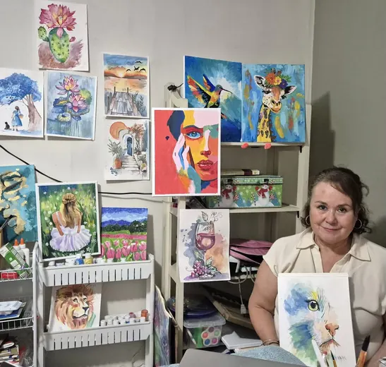 Alumna con sus cuadros de acrílico y acuarela